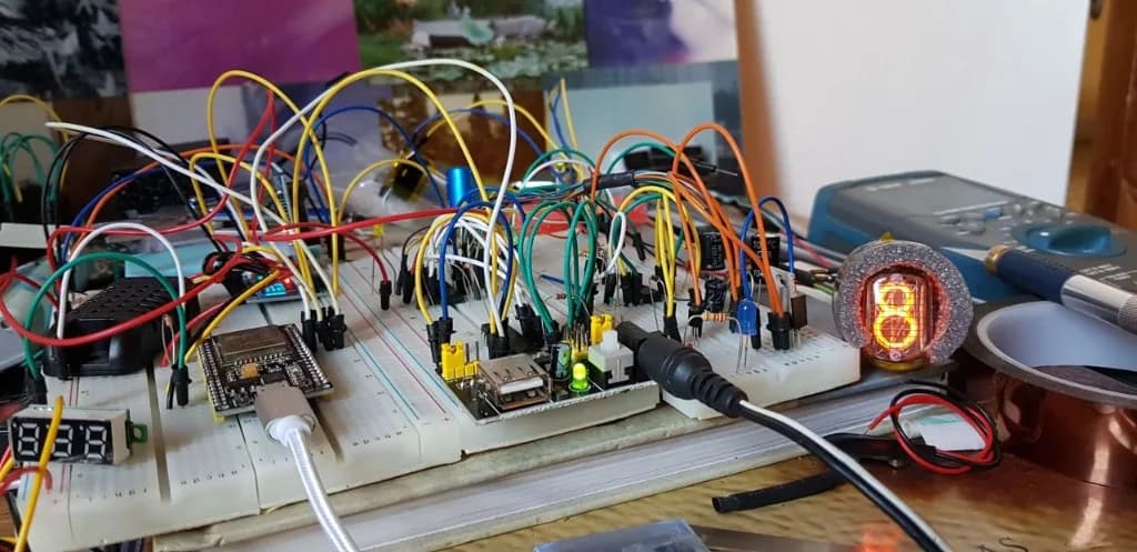 Breadboard bring-up — ESP32, jumper-wire spaghetti, one nixie tube glowing orange with the digit 8
